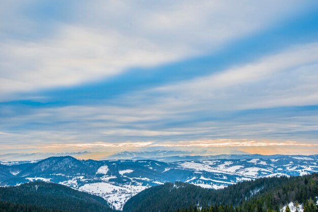 Beautiful panorama of mountain slopes with trails overlooking the hills and coniferous forests