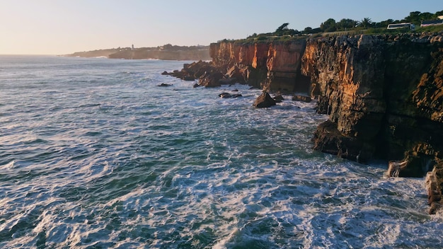 Beautiful panorama rocky shoreline at evening sunlight drone view ocean waving