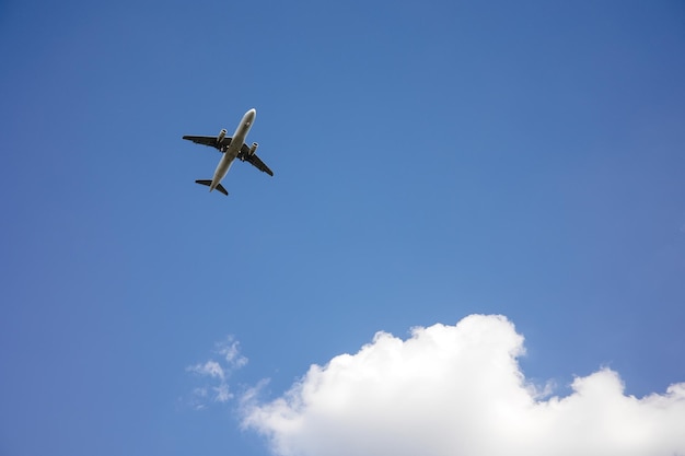 青い空に飛行機が飛んでいる美しいパノラマの背景。旅客機