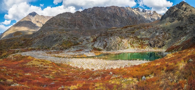 Beautiful panoramic view of the autumn misty valley View from high mountain on picturesque landscape Colorful nature clear lake stone river and yellow dried grass environment