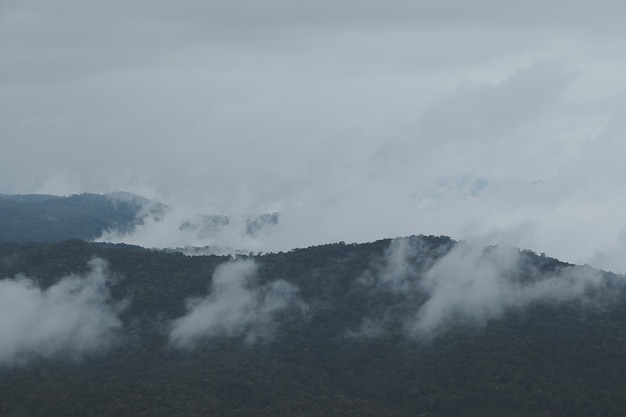 Photo beautiful panoramic view of fog and clouds in distant layers mountains range with blue sky in morning