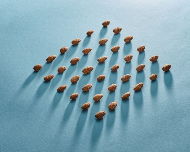 Beautiful pattern of almonds on paper blue background