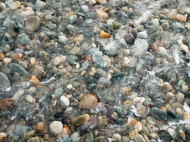 Beautiful pebbles under water with foam