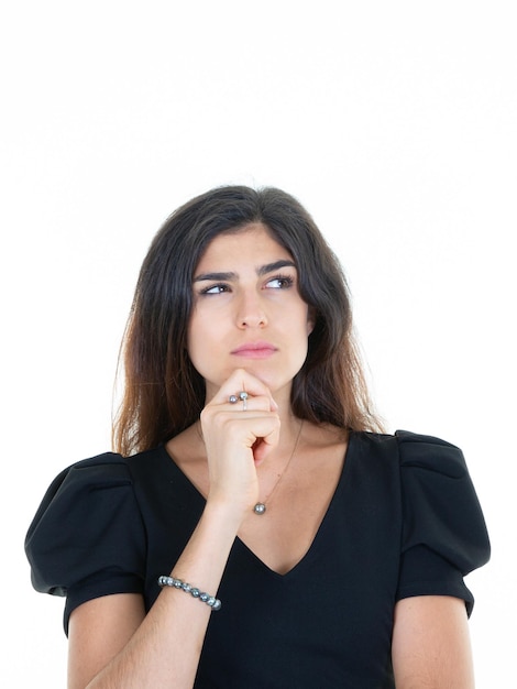 Beautiful pensive woman looking up side hand on chin