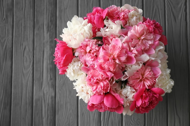 Beautiful peonies on wooden background