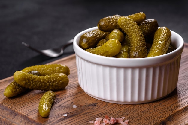 Premium Photo | Beautiful pickled cucumbers of small size on a dark concrete background