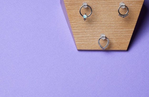 Beautiful piercing jewelry on wooden display Macro shot Selective focus