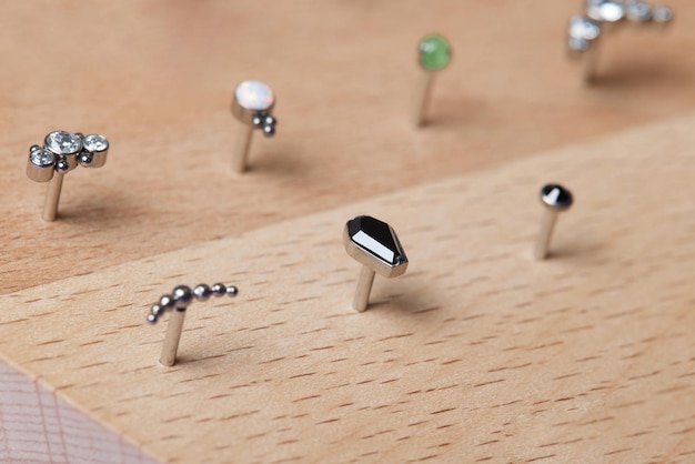 Beautiful piercing jewelry on wooden display Macro shot Selective focus