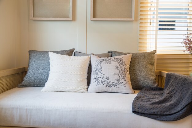 Beautiful pillows on beige fabric sofa in livingroom.