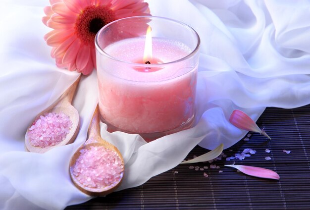 Beautiful pink candle with flower on bamboo mat