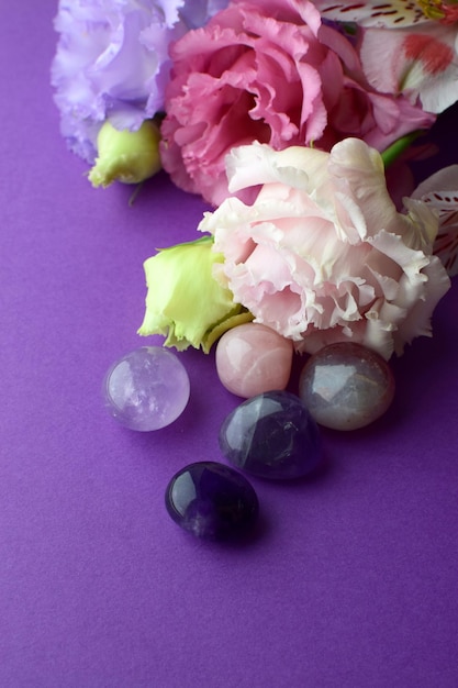 Photo beautiful pink eustoma flowers lisianthus in full bloom with natural stones amethyst and rose quartz