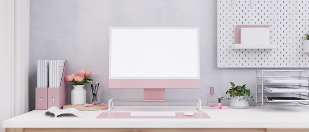 A beautiful pink female office desk with a modern pink computer and office supplies on the desk