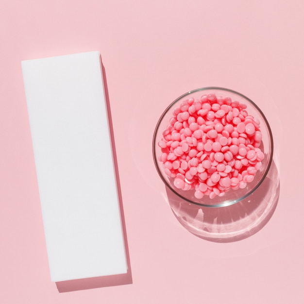 Beautiful pink granules and strips for depilation on a pink background Epilation depilation