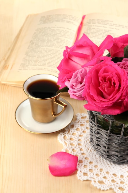 Beautiful pink roses in vase on wooden table close-up