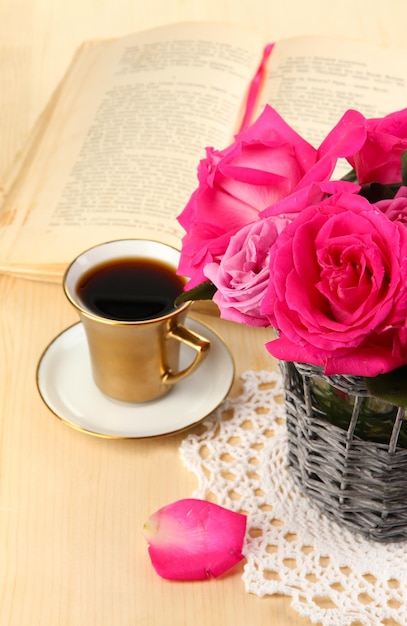 Beautiful pink roses in vase on wooden table close-up