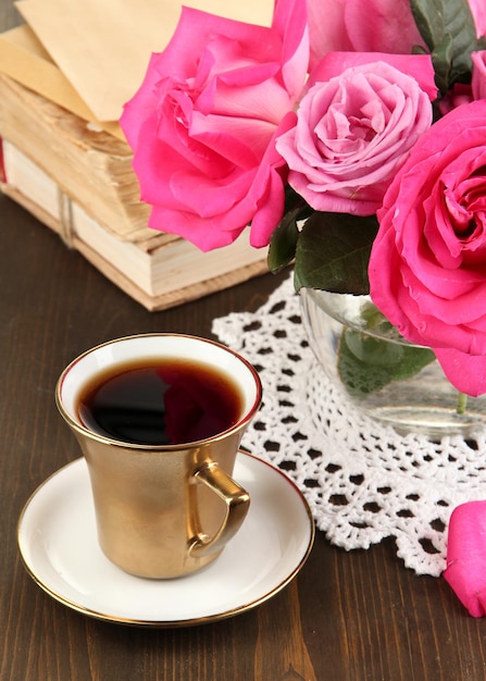 Beautiful pink roses in vase on wooden table close-up