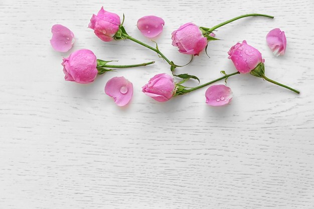 Beautiful pink roses on wooden background