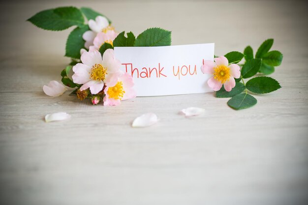 beautiful pink small roses on a branch on a wooden table