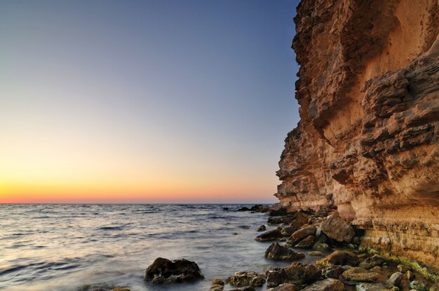 Beautiful pink sunset, rock and water stones with green moss landscape