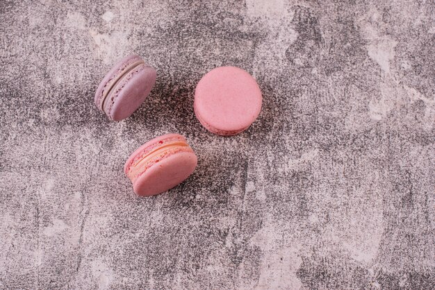 Beautiful pink tasty macaroons on a concrete background