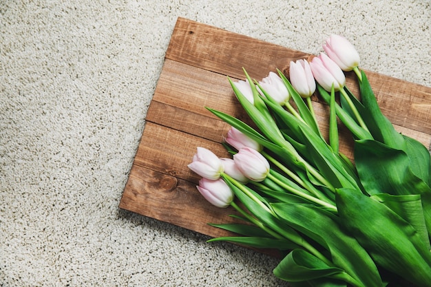 Beautiful pink tulip flowers on the wooden board