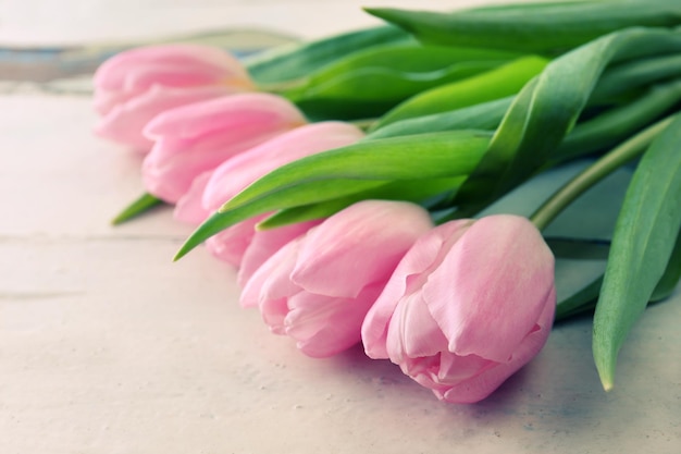 Beautiful pink tulips on wooden background