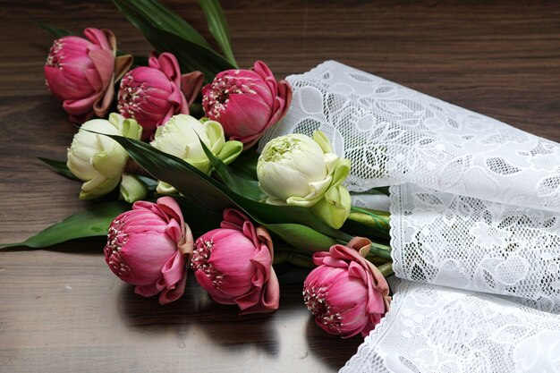 Bellissimo fiore di loto rosa e bianco per pregare buddha su fondo in legno