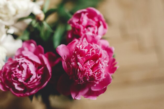 Foto bellissimo bouquet di peonie rosa e bianche in barattolo di vetro su pavimento in legno rustico piatto disteso decorazioni floreali e disposizione raccolta di fiori natura morta rurale fiori di campagna
