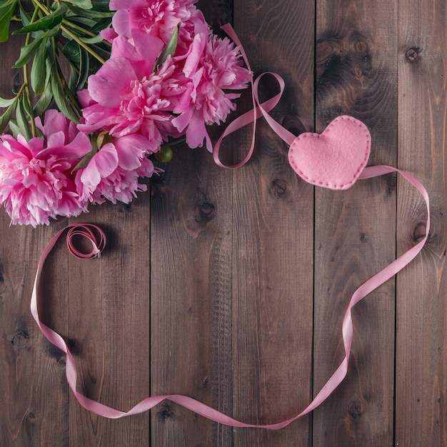 Beautiful pink and white peonies on wooden background