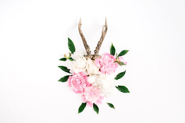 Beautiful pink and white peony flowers bouquet and goat horns on white background. flat lay, top view