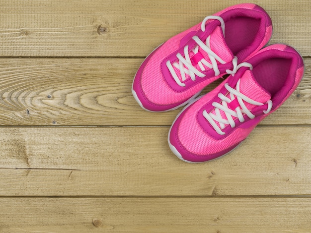 Beautiful pink women's running shoes vintage on the floor. The view from the top.