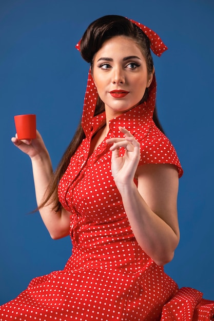 Beautiful pinup girl posing in a blue studio