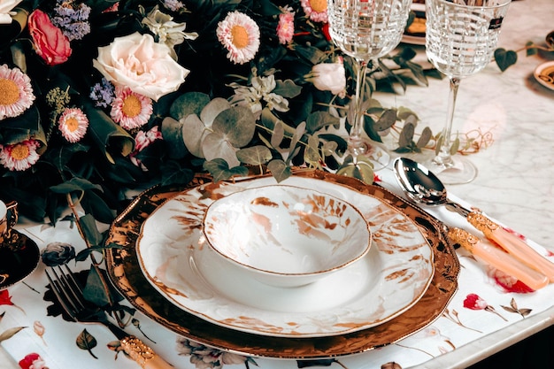 красивая тарелка и свежие прекрасные красочные цветы, стоящие на роскошном столе