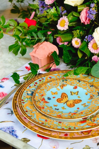 Photo beautiful plate and fresh perfect colorful flowers standing on luxury table