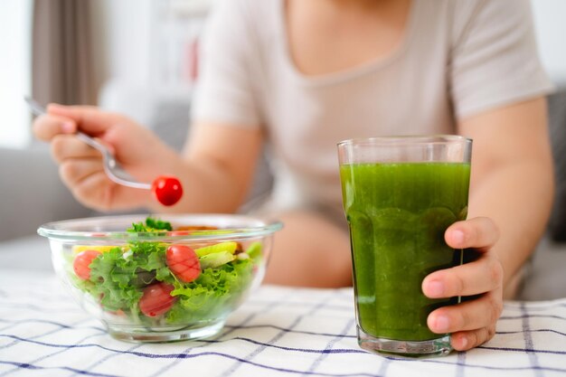 サラダの鉢を握ってその鉢でサラダを食べている美しい太った女性