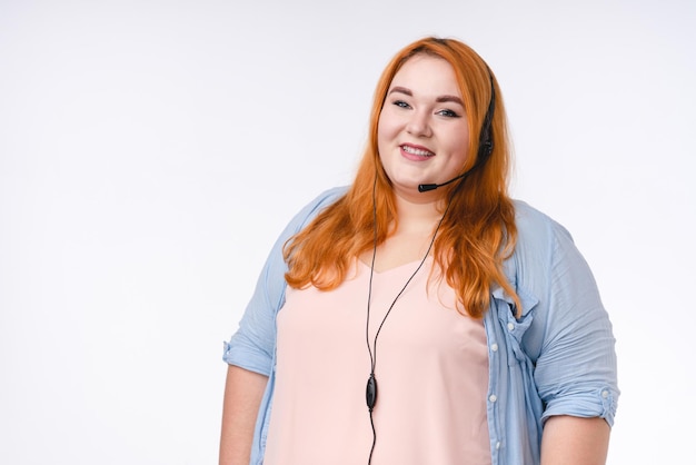 Beautiful plus size redhaired woman in dispatchers headset isolated over white background