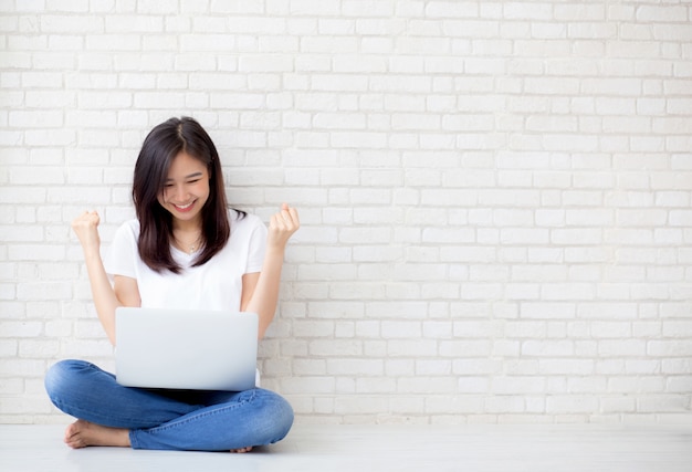 Beautiful of portrait asian woman excited and glad of success with laptop computer