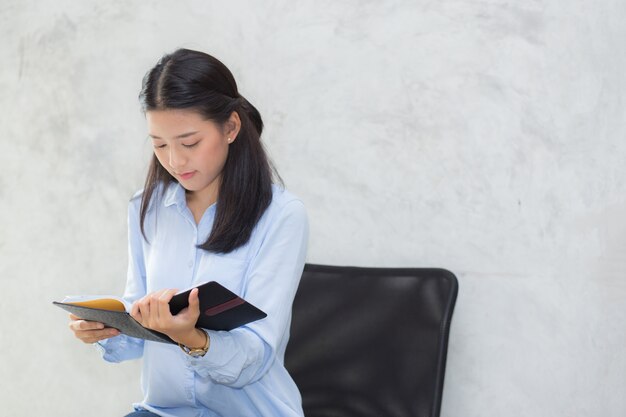 Beautiful of portrait business asian young woman reading on notebook