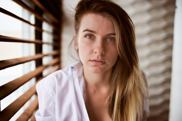 Beautiful portrait of a girl against the background of a window Casual shooting style