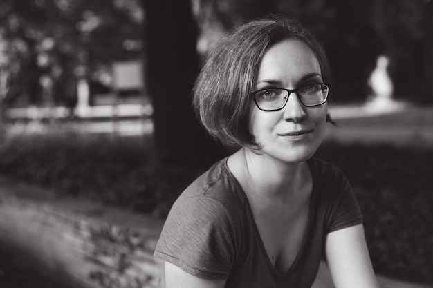 Beautiful portrait of a girl with glasses rest in the park