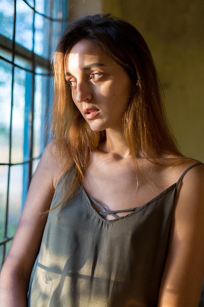 Beautiful portrait of a girl on a wooden background Girl in a light dress on the straps