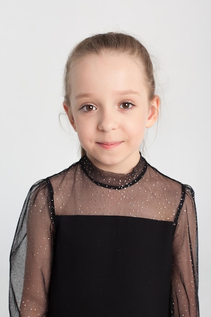 Beautiful portrait of a happy smiling cute girl in the studio on a white background children's emotions