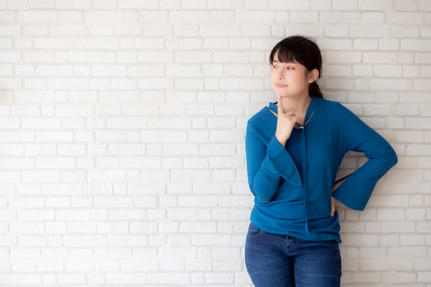 Beautiful portrait young asian woman confident thinking with cement and concrete background