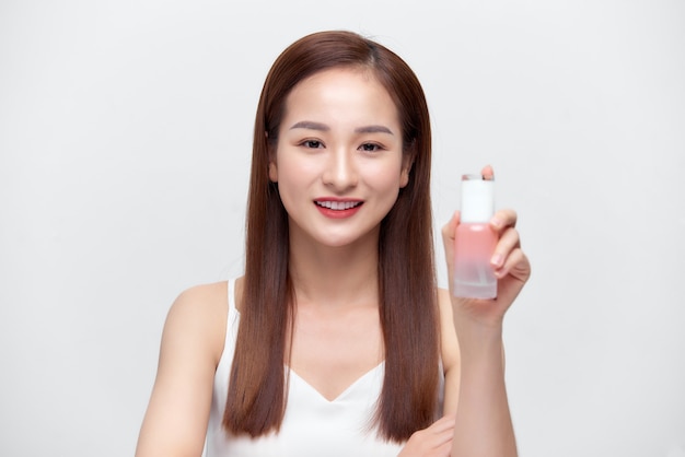 Beautiful portrait young asian woman holding and presenting cream or lotion product,