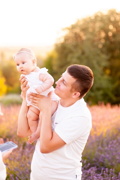 라벤더 밭에 아기가 있는 젊은 가족의 아름다운 초상화. 가족 사랑과 가치 개념입니다.