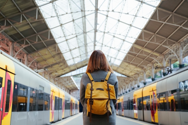 Beautiful portuguese woman traveler waiting at train station. Travel and vacation concept. Urban lifestyle.