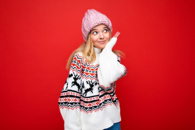 Beautiful positive happy young blonde woman isolated over colourful background wall wearing casual stylish clothes feeling sincere emotions looking to the side