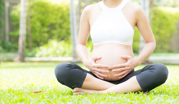 Beautiful pregnant asian young woman relax in the park.