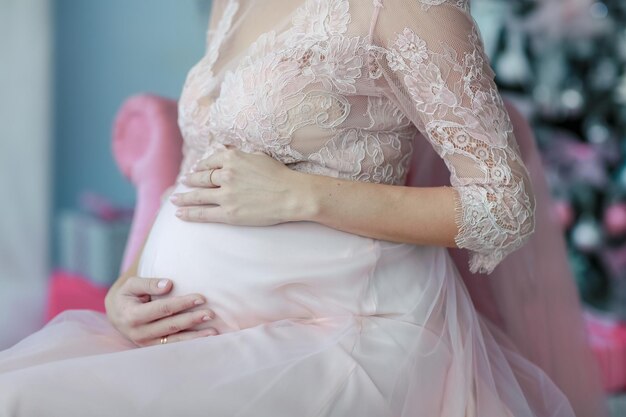 Beautiful pregnant bride in a bright room near the christmas tree