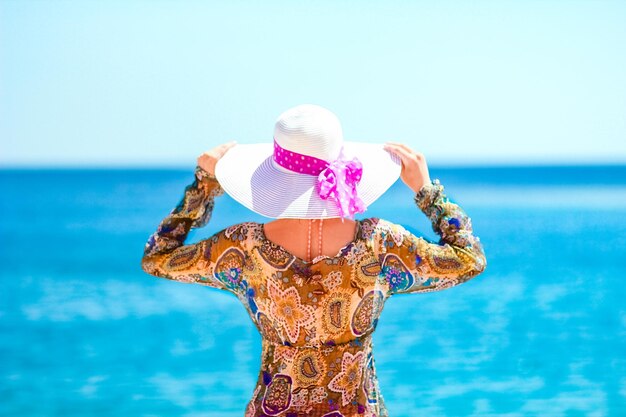 Beautiful pregnant girl in hat at sea background